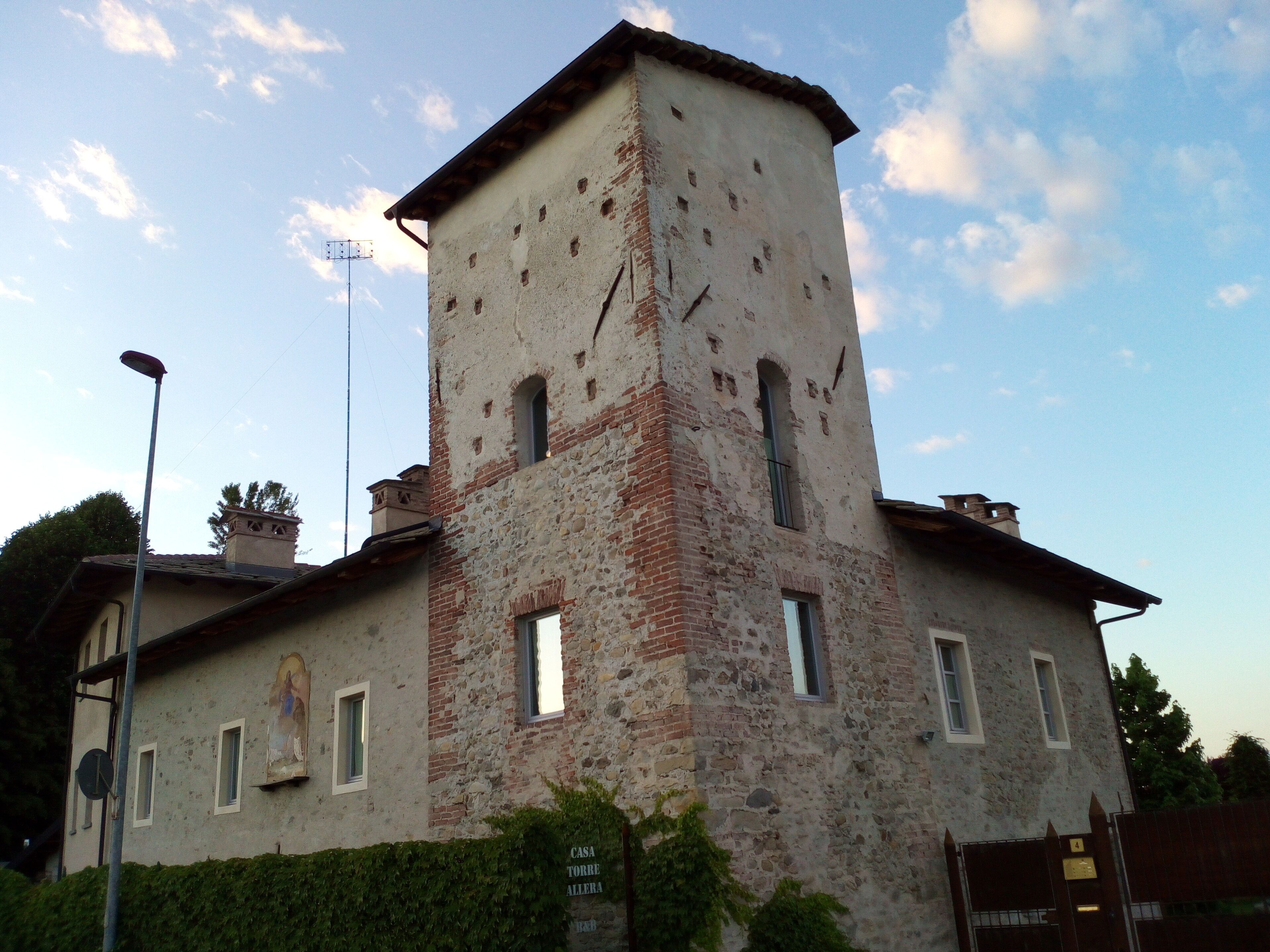 A historic building with a tower, multiple windows, and a sign indicating it is a house.