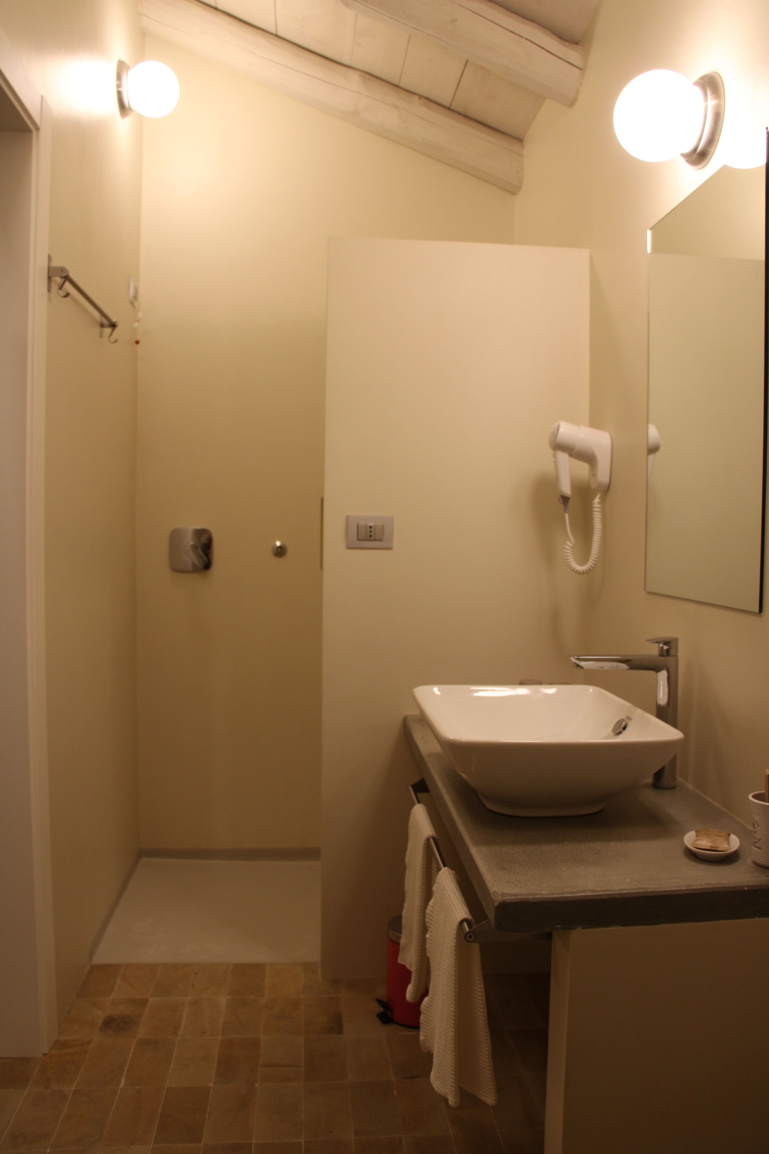 A bathroom with a sink, mirror, and hairdryer.