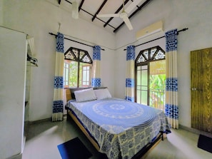 A bedroom with a bed, curtains, a window, and an air conditioning unit. - DiNi Galle (Galle)
