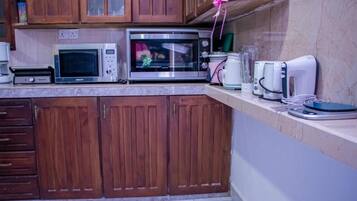 Eine Küche mit Holzausstattung, einer Mikrowelle, einem Toaster und einer Kaffeemaschine.