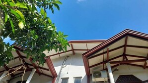 A building with a white facade, a brown roof, and a balcony with a metal railing. - DiNi Galle (Galle)