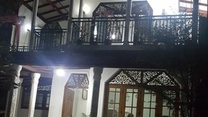 A two-story building with a balcony, large windows, and potted plants. - DiNi Galle (Galle)