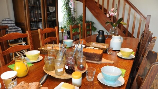 Taula de menjador preparada amb diversos aliments, com pa, mantega i condiments.