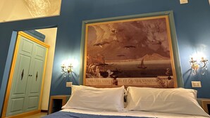 A bedroom with a large bed, a blue wall, and a painting above the bed. - La Bella Napoli B&B (Naples)