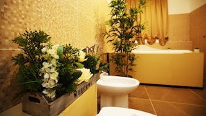 A bathroom with a wooden planter with flowers, a white sink, and a bathtub. - La Bella Napoli B&B (Naples)