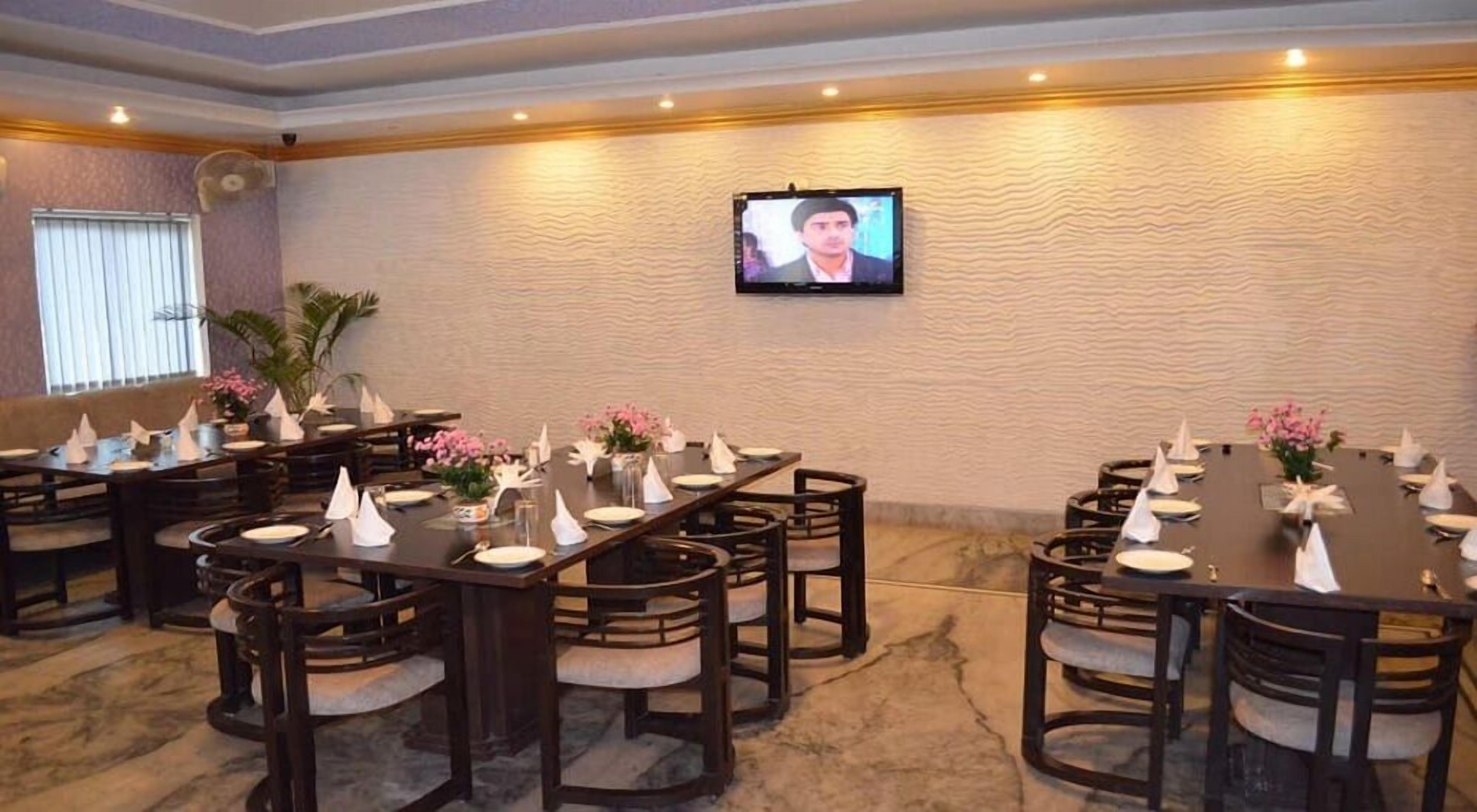 A conference room with multiple tables set for meetings, equipped with chairs and floral centerpieces.
