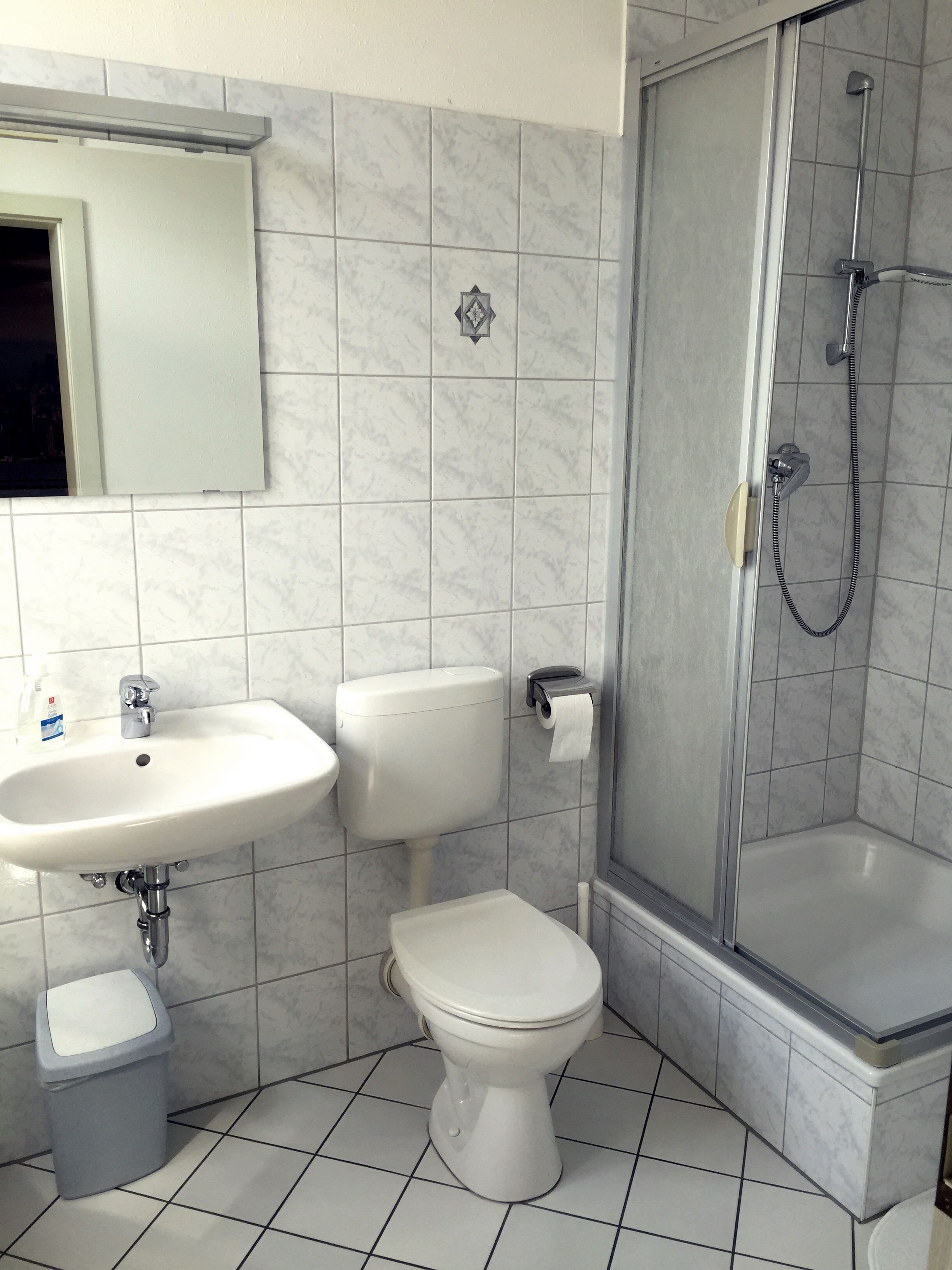 A bathroom with a sink, toilet, and shower.
