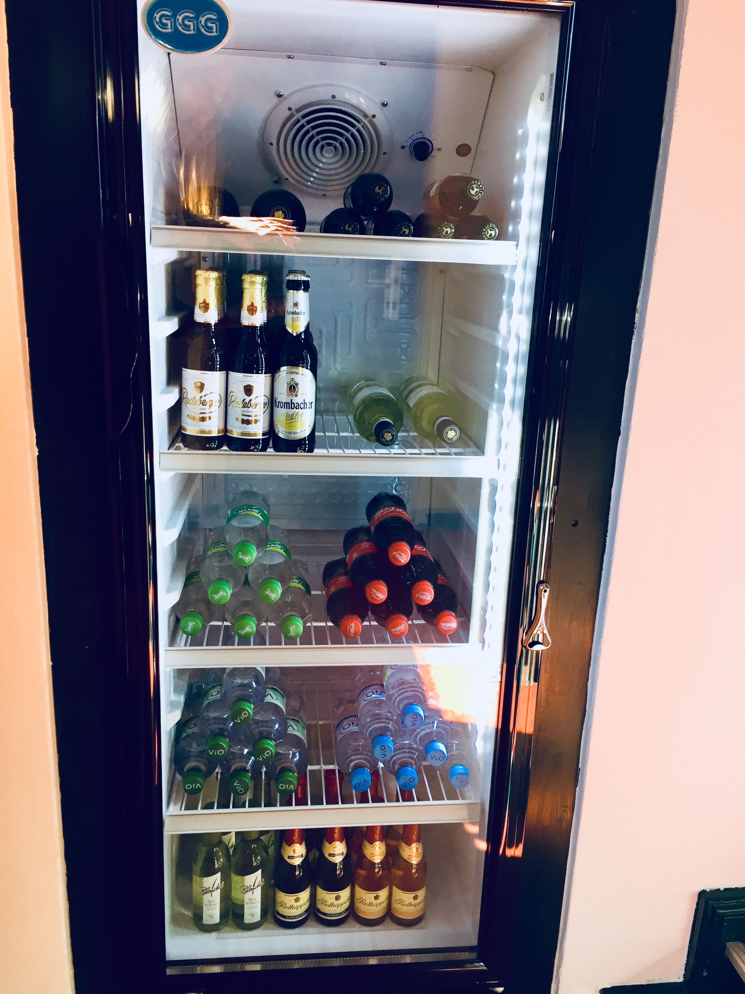 Ein Getränkekühlschrank, gefüllt mit verschiedenen Flaschen, darunter Champagner und Limonade.