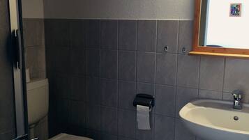 Ein Badezimmer mit Toilette, Waschbecken und Spiegel.