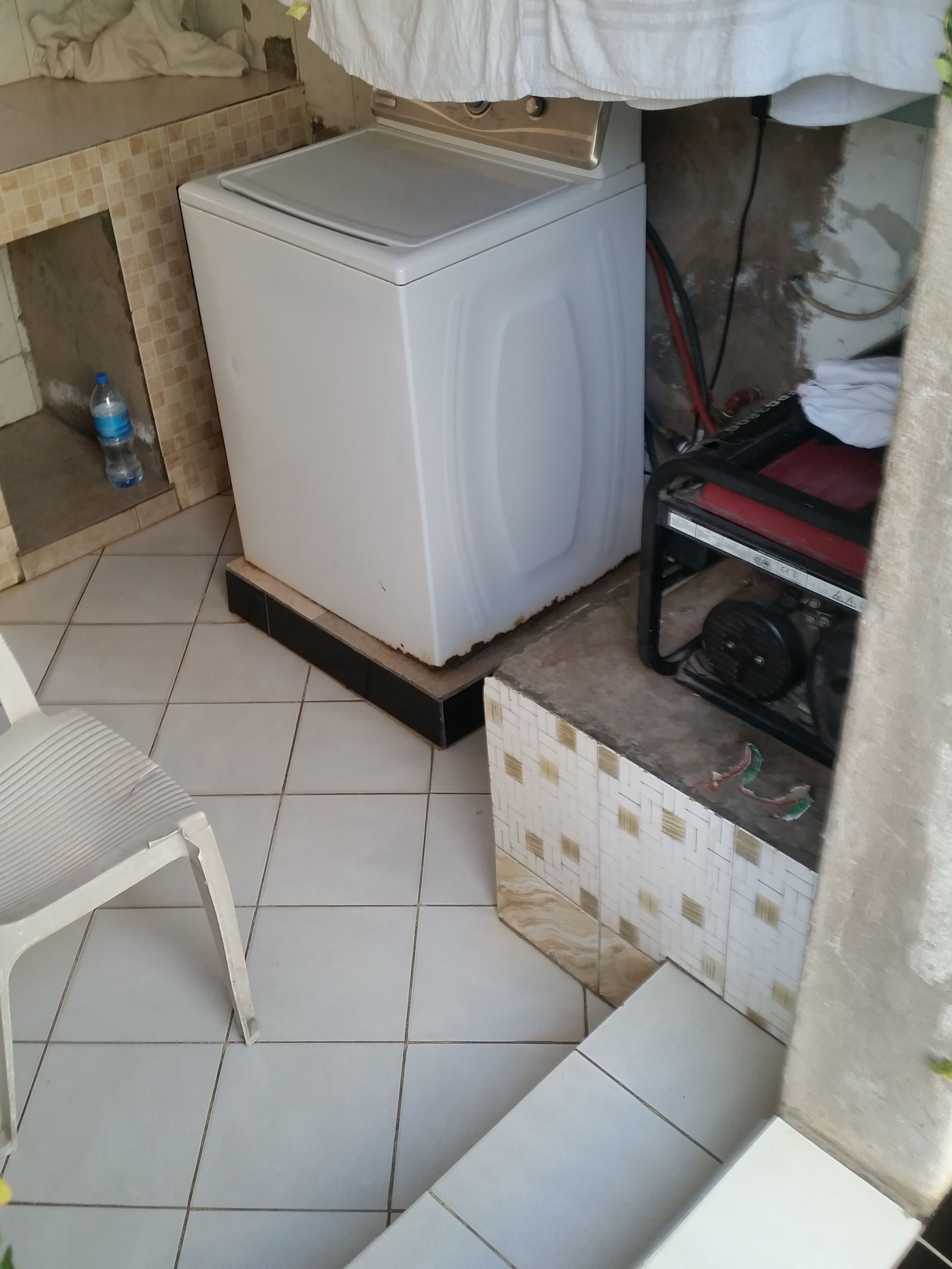 Una cocina compacta con un refrigerador blanco, dispensador de agua y un lavamanos pequeño.