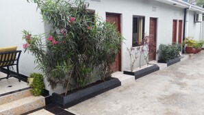 A building with a tiled entrance, a bench, and potted plants. - Raha Leo Inn (Arusha)