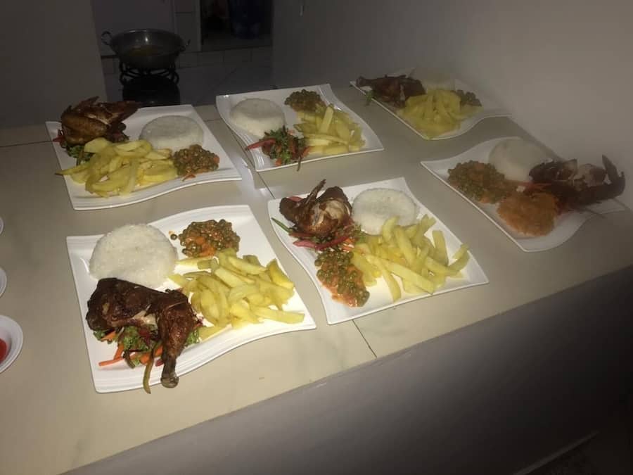 A table with multiple plates of food, including rice, fried chicken, and fries.