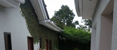 Un espacio al aire libre techado con piso de baldosas, un extintor y un banco.