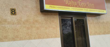 A sign for Raha Leo Inn with contact information.