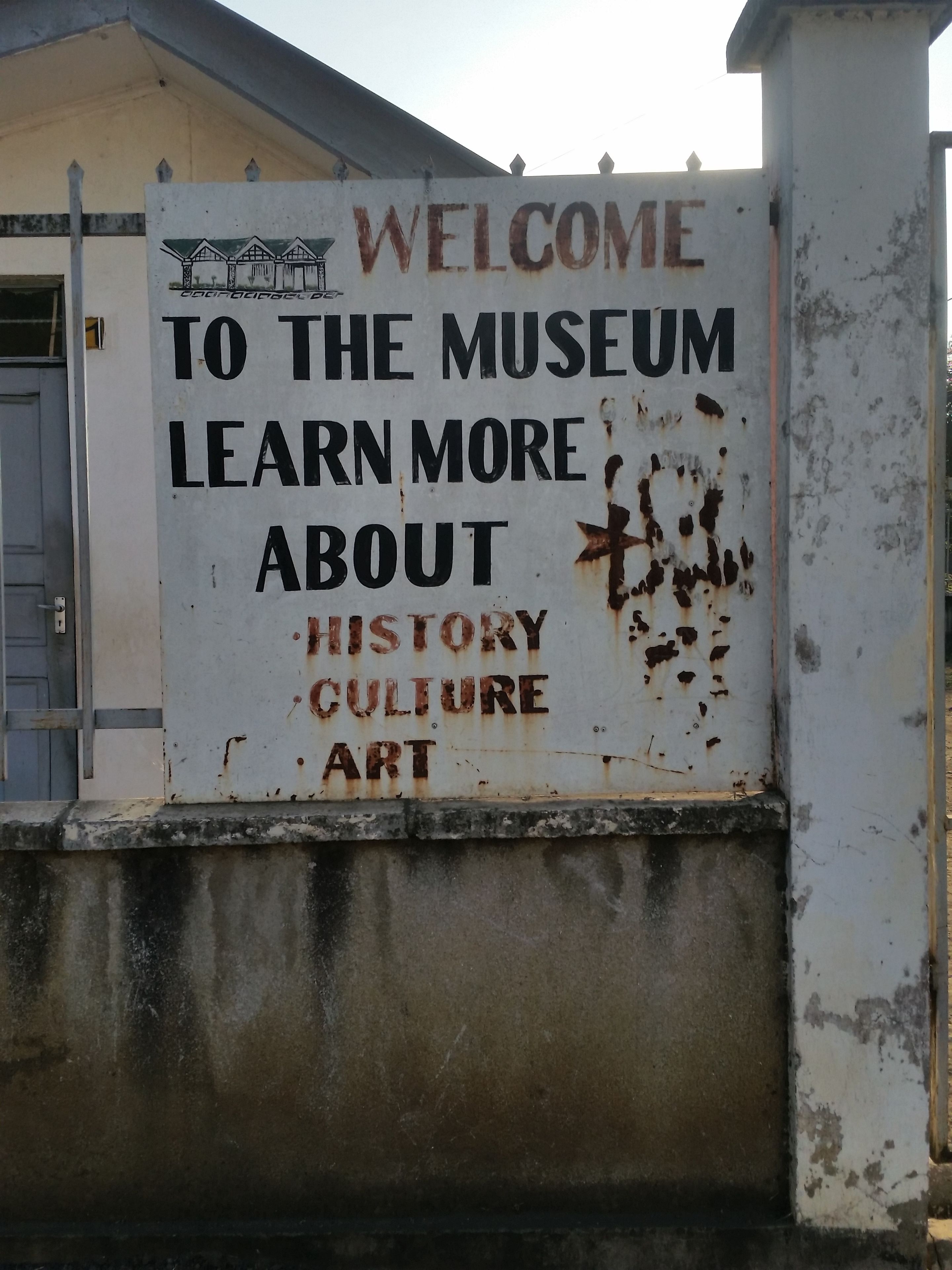 A sign welcoming visitors to a museum, indicating that the museum offers information about history, culture, and art.