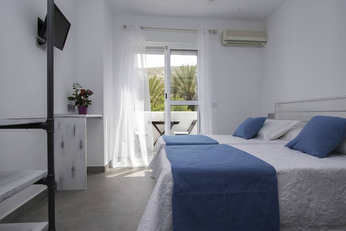 Habitación doble, balcón (vista lateral al mar) | Cortinas blackout, tabla de planchar con plancha y ropa de cama