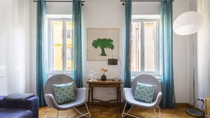 A modern living room with two grey chairs, a wooden table, and a blue sofa. - ROMAC - Condotti I (Rome)