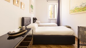 A hotel room with a bed, a bedside table with toiletries, a chair, and a window with curtains. - ROMAC - Condotti I (Rome)