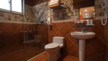 Un baño con ducha, inodoro y lavabo.