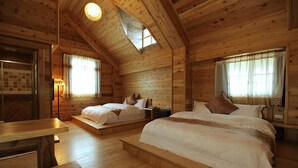 Quarto de cabana de madeira aconchegante com duas camas, uma mesa de madeira e um claraboia.