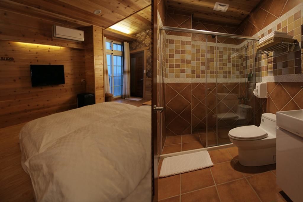 A wooden room with a bed, a TV, and a shower area with a tiled wall.
