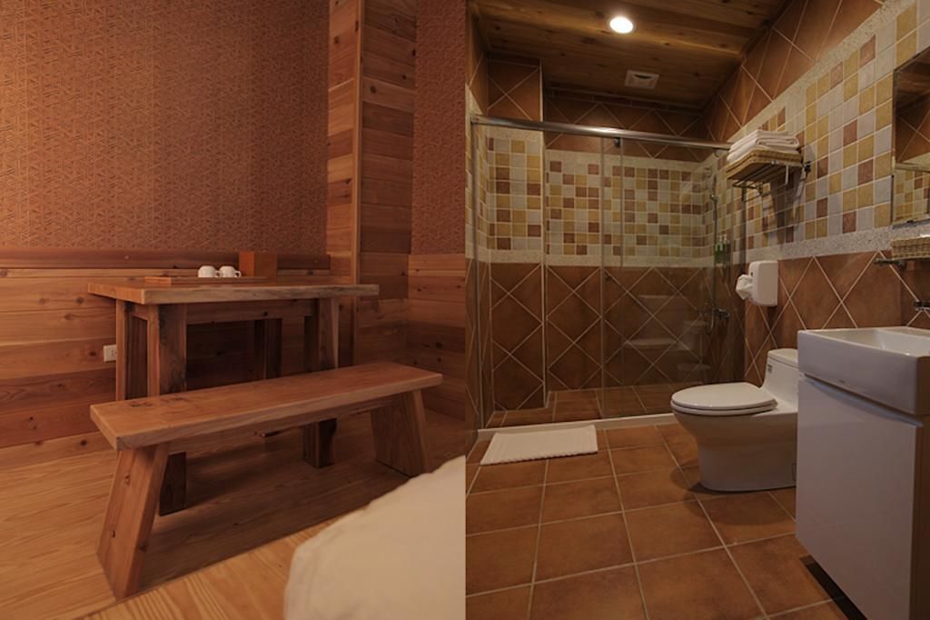 Baño de cabaña de madera con banco, inodoro y zona de ducha.