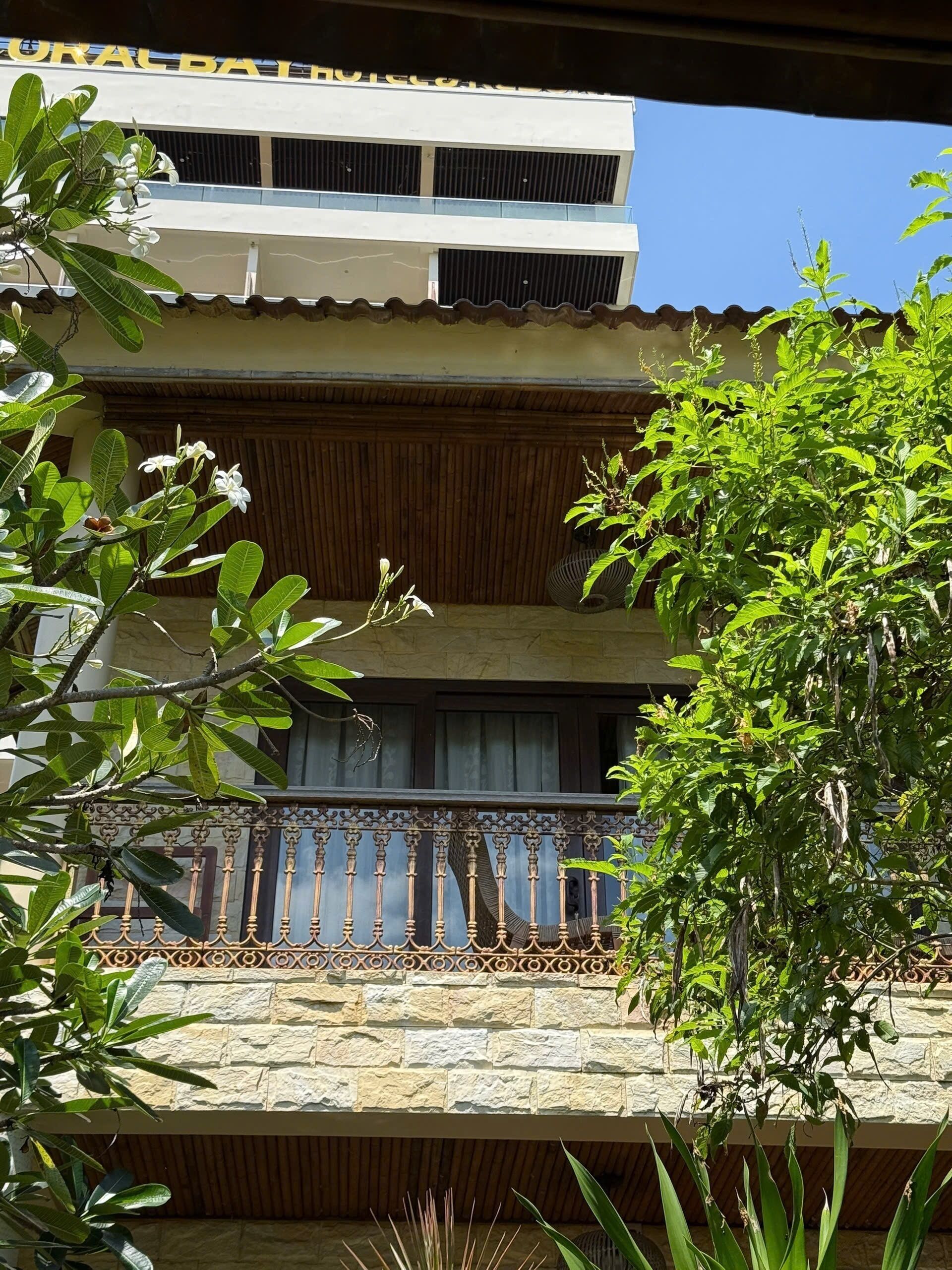 Un hotel con balcón que presenta barandilla decorativa y vista del exterior del edificio.