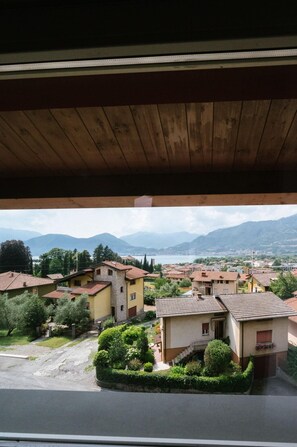 A residential area with houses, a clear view of mountains, and a body of water in the background. - Lake Hotel La Pieve (Pisogne)