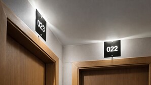Two wooden doors with numbers 022 and 023 above them, indicating room numbers. - Hotel Zenite (Angra do Heroismo)