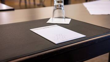 Una mesa con un objeto de vidrio transparente y un papel blanco con un logotipo.