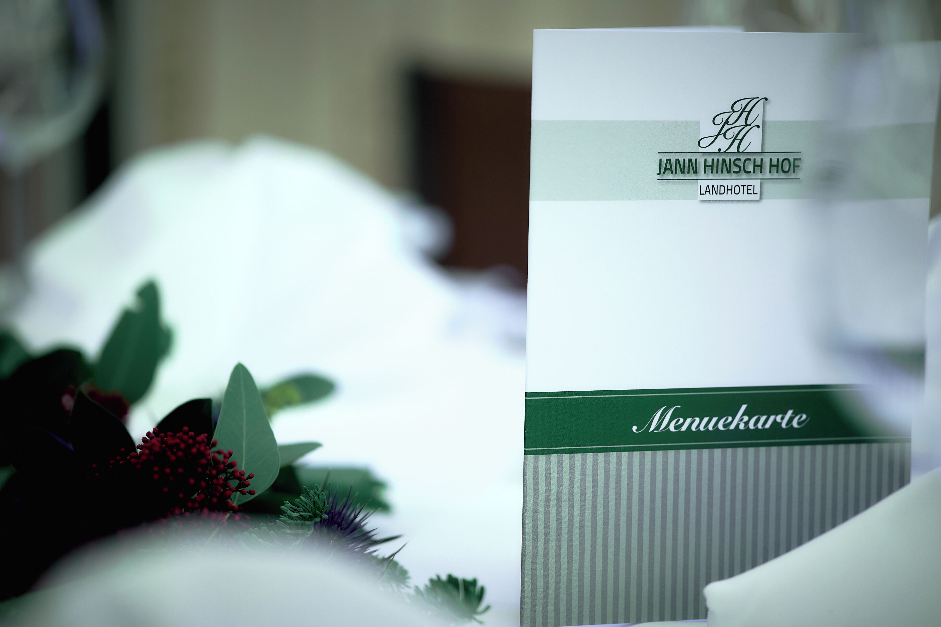 A menu card from Jann Hinsch Hof Landhotel with a logo and name.
