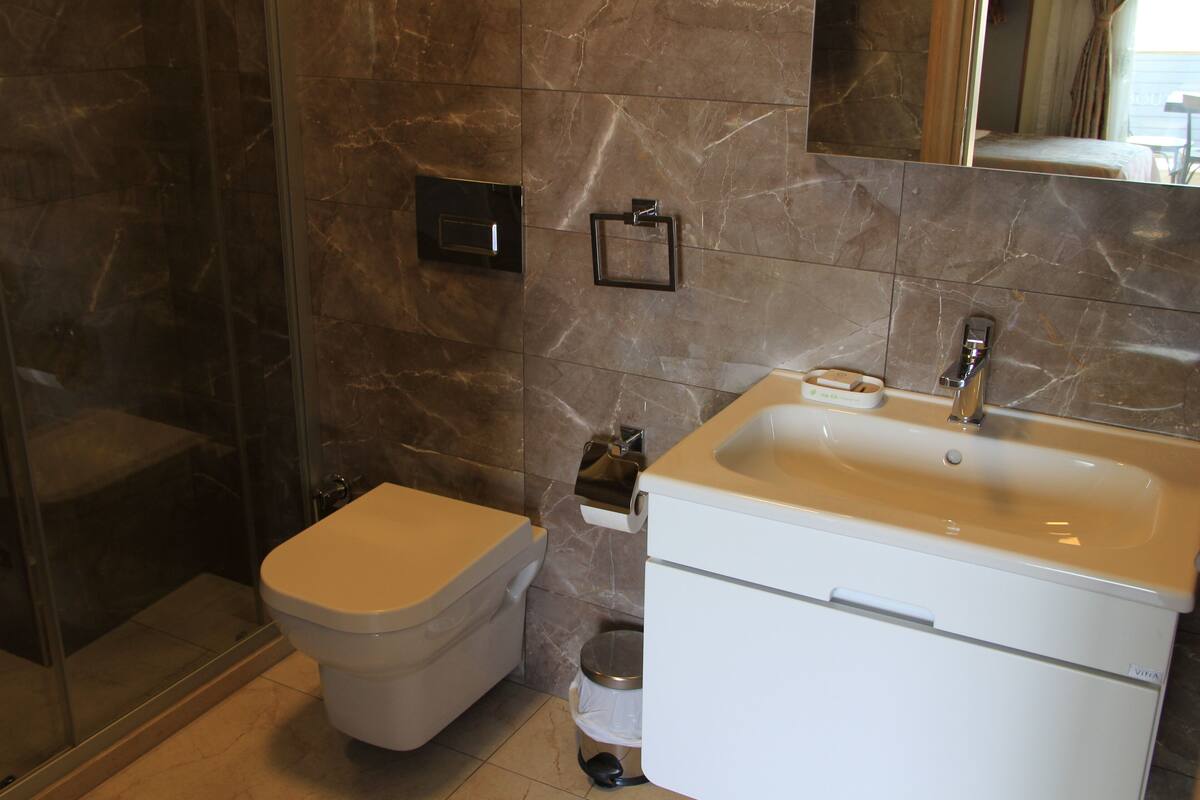 deluxe triple room, partial sea view | bathroom | shower, free toiletries, hair dryer, slippers