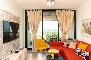 Suite Deluxe, 1 grand lit, vue océan, vue mer | Coin séjour | Télévision à écran plat, films à la carte