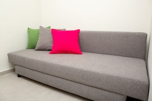 A grey sofa with three cushions in different colors. - Sea View Suite (Hof HaCarmel)