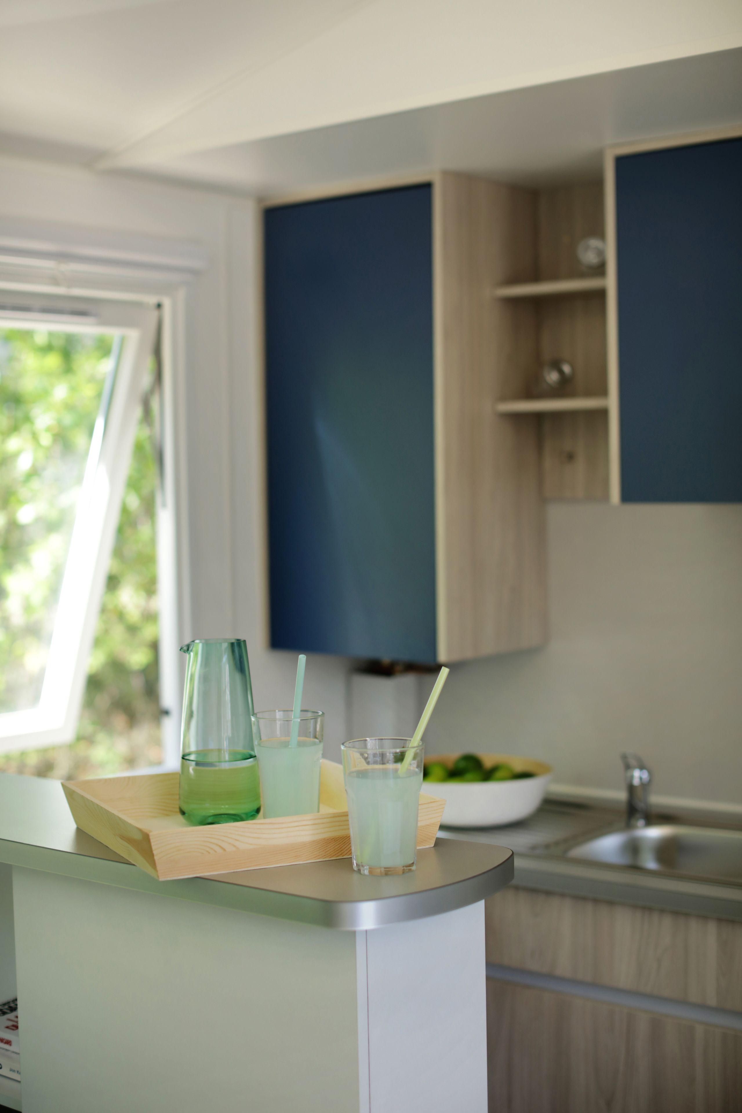 A modern kitchen with a wooden countertop, a sink, and cabinets.