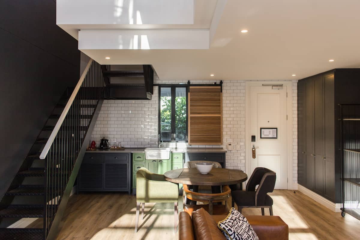 Una cocina moderna con comedor, una escalera y vistas al exterior.