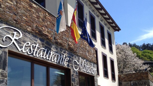 Ein Restaurant mit steinverkleideter Fassade, Außenbereich und Flaggen.