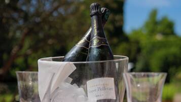 Une bouteille de champagne dans un seau à glace, posée sur une table avec des verres à vin vides.