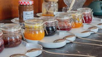 Une table de buffet avec différents pots contenant des aliments et des cuillères.