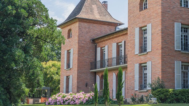 A large brick building with a tower, white shutters, and a balcony. - Castel Bois Marie (Montauban)