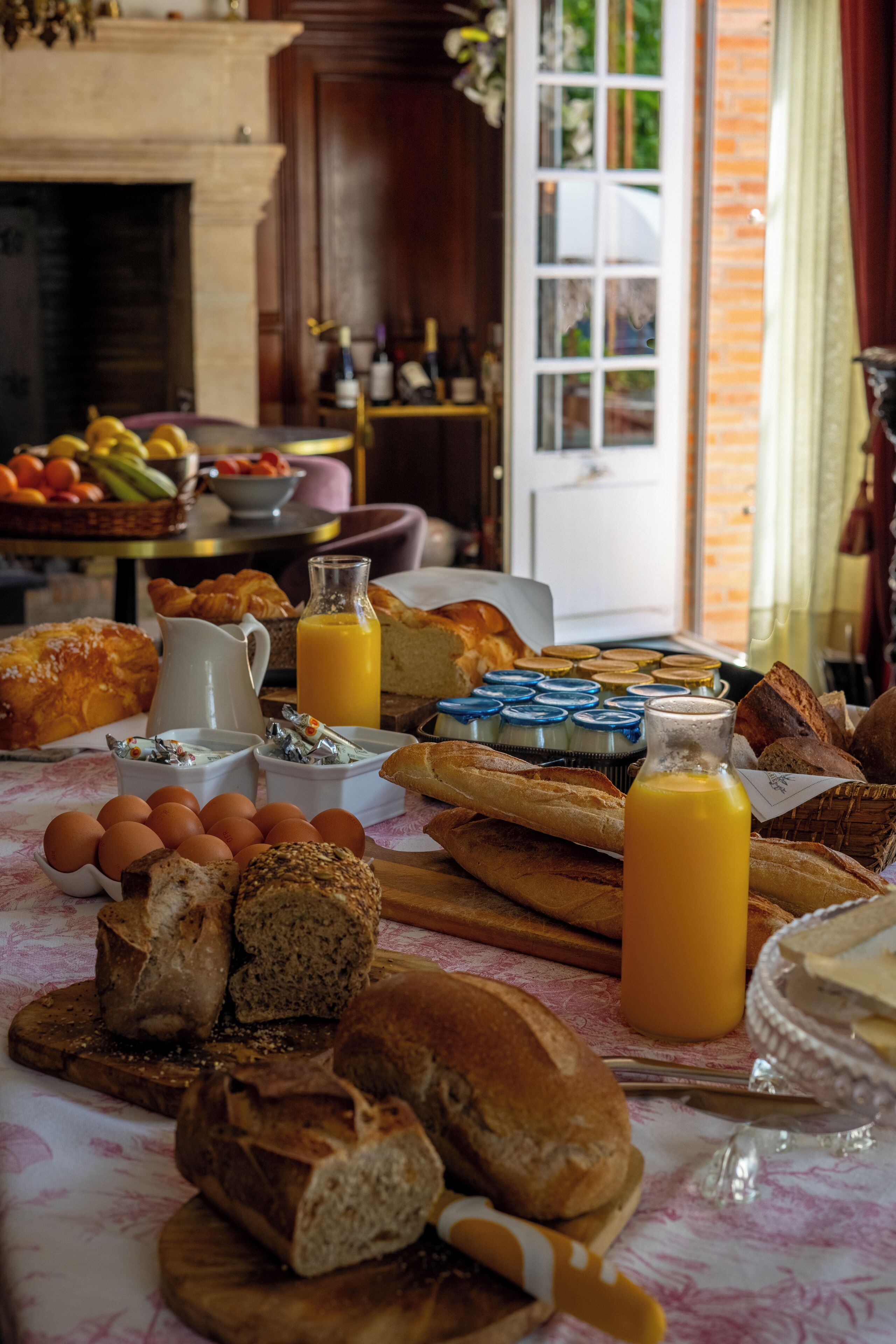 Une table de petit-déjeuner avec du pain, des œufs et du jus de fruits.