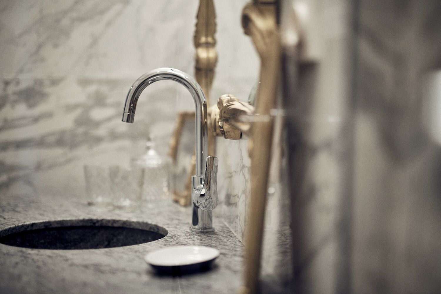 A bathroom with a modern faucet, a sink, and a mirror.