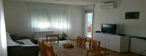 A living room with a TV, dining table, chairs, and a sofa. - Brand new Apartment MARIN (Split)