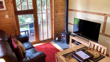 Deluxe Cabin, 1 Bedroom, Non Smoking, River View | Living room | 40-inch flat-screen TV with satellite channels, TV, fireplace