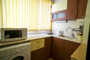 Enjoy cooking in this fully equipped kitchen with a washing machine, microwave, and sink.
