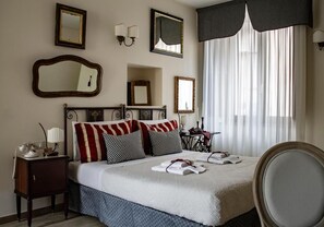 A hotel room with a bed, bedside tables, a chair, and a window with curtains. - Albergo Merùo (Morano Calabro)