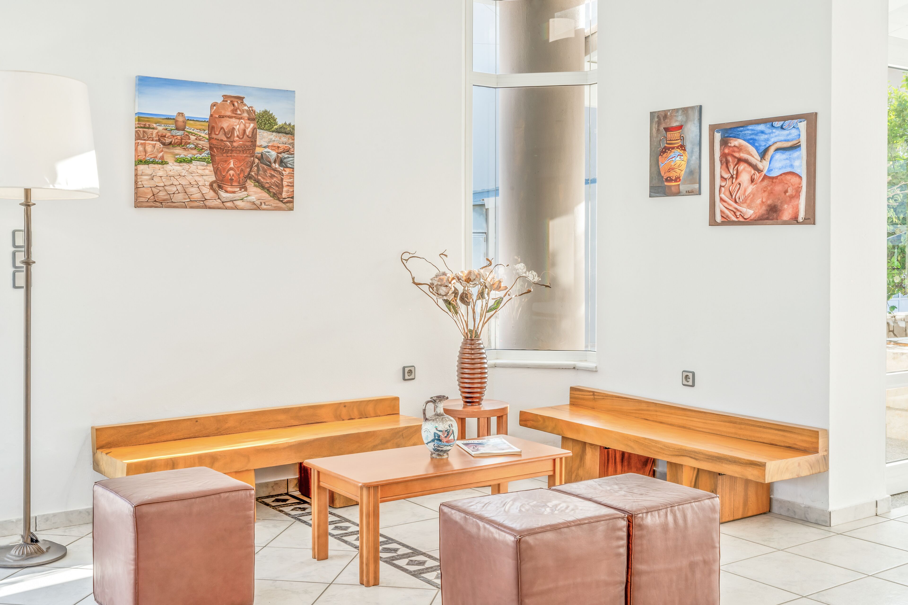 A modern interior with wooden benches, a table, and artwork on the walls.