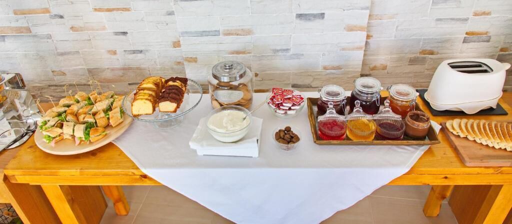 A buffet table with sandwiches, desserts, and various condiments.