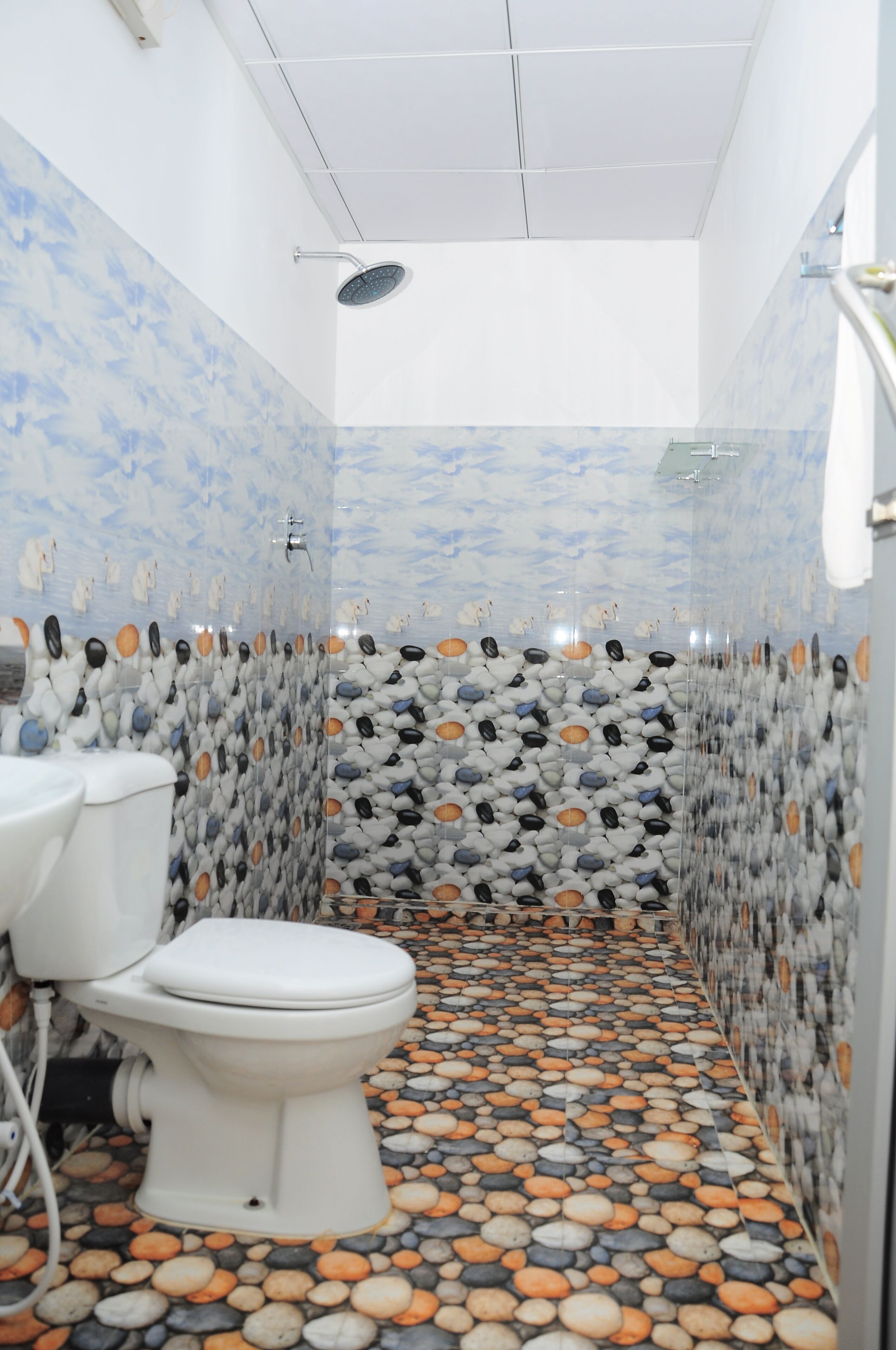A bathroom with a toilet, shower, and tiled walls.