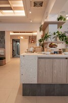 Una cocina moderna con una isla central, armarios de madera y una variedad de plantas.